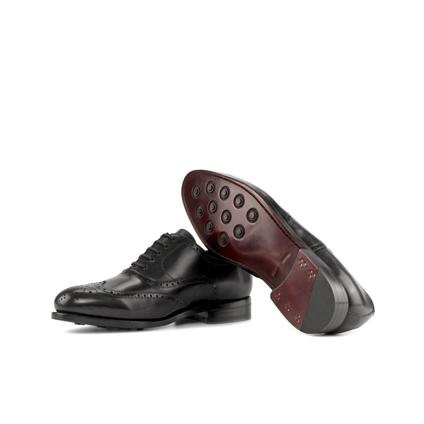 Wingtip Oxford in Black Box Calf showing dark red leather sole with rubber button injections