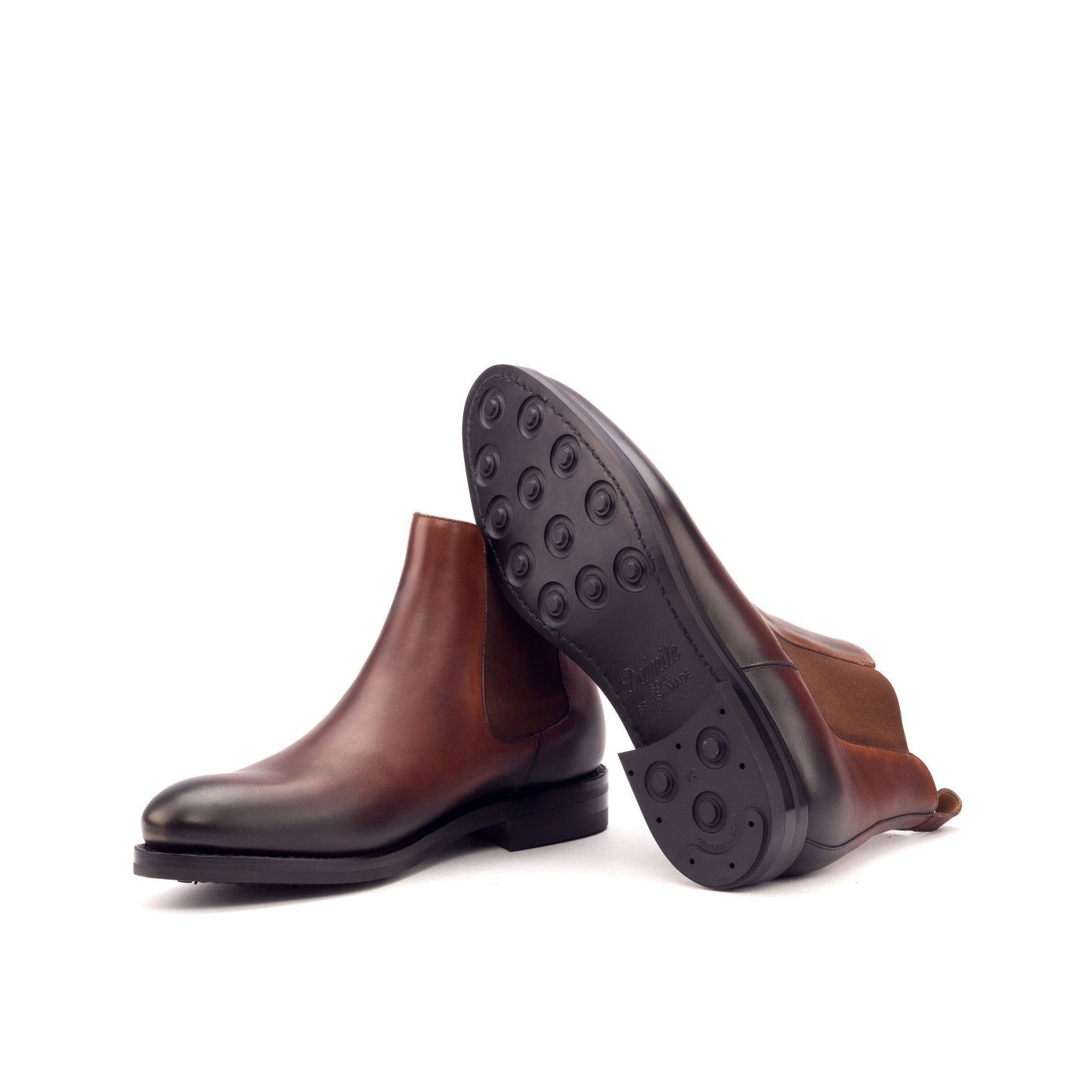 Burnished medium brown painted box calf Chelsea boots showing black Dainite rubber soles