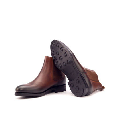 Burnished medium brown painted box calf Chelsea boots showing black Dainite rubber soles