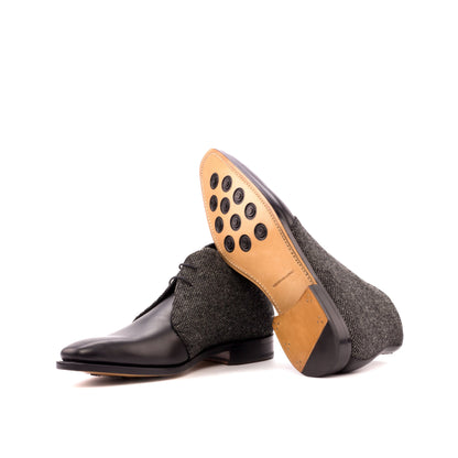 Chukka Boot in Black Box Calf and Black Nailhead Fabric showing natural leather sole with rubber button injections
