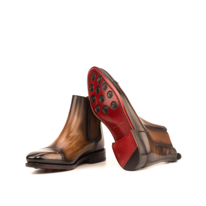 Burnished medium brown box calf Chelsea boots showing dark red leather soles with rubber button injections