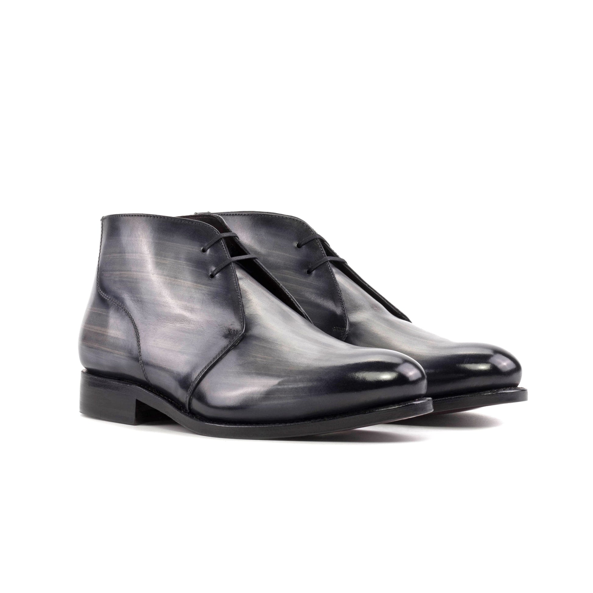 Pair of grey patina box calf Chukka boots with burgundy round laces, front three-quarter view